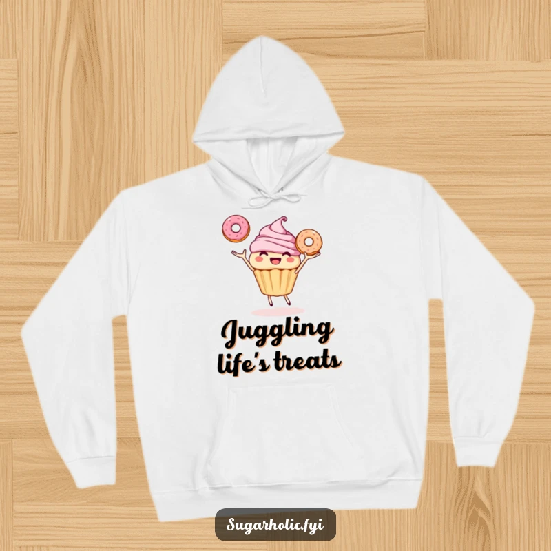 Funny hoodie featuring a smiling cupcake character joyfully juggling three donuts, offering cozy warmth and sweet, humorous delight.